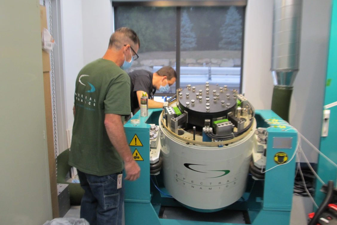 Two Spectral Dynamics Engineers making a repair of a shaker system.
